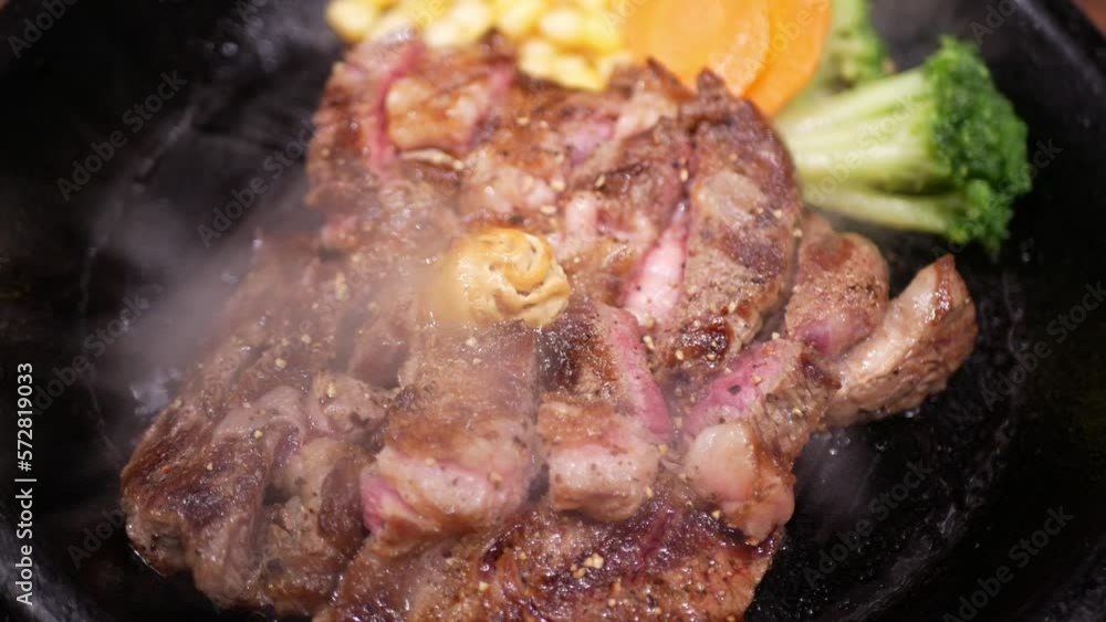 close up cooked of delicious sirloin steak served on a hot pan plate with roasted vegetable and many smoke from plate close up cooked of delicious sirloin steak served on a hot pan plate with roasted vegetable and many smoke from plate
