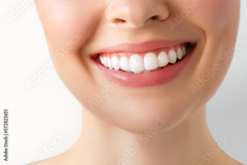 Perfect white teeth smile of a young woman. The result of the teeth whitening procedure. The image symbolizes oral care dentistry  Closeup on a white background.