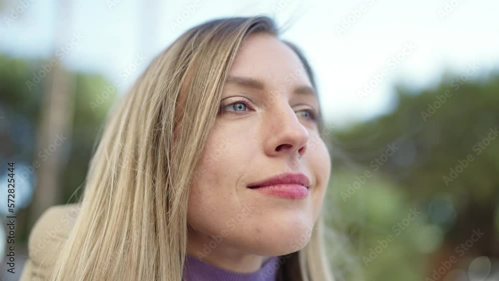 Young blonde woman looking to the side with relaxed expression at park Young blonde woman looking to the side with relaxed expression at park