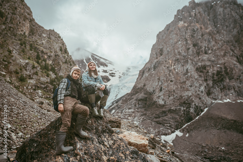 Boy and adult woman sitting in the Altay mountains 