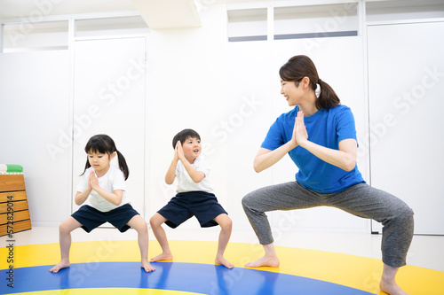 室内で運動をする子供たちと先生