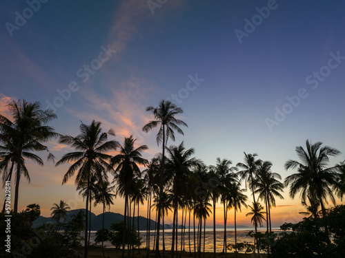 Aerial view stunning sky at sunrise above coconut trees..Wonderful aerial view of colorful landscape during the sunset. Flying over Laem Had sand beach. .Aerial view of Laem Had Beach in Koh Yao Yai. © Narong Niemhom
