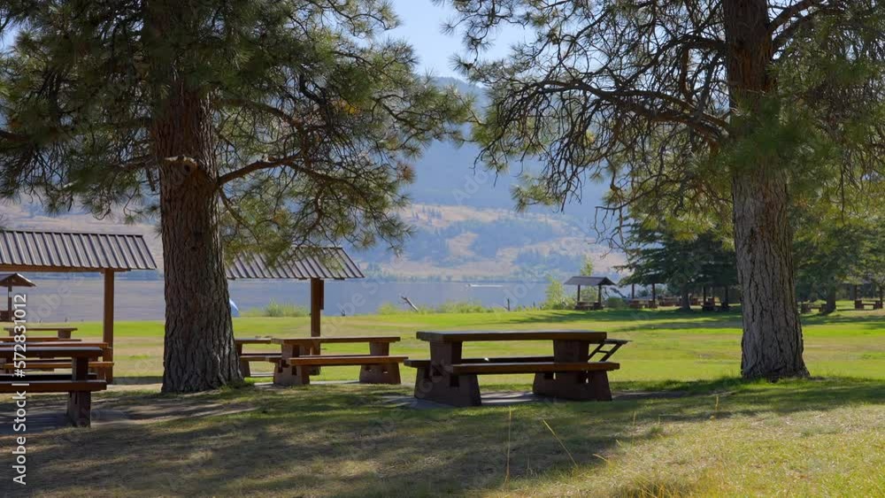 Establishing shot of Mountain lake with blue sky and picnic bench in Vancouver, Canada, North America. Day time on July 2022. Still camera view. ProRes 422 HQ. Establishing shot of Mountain lake with blue sky and picnic bench in Vancouver, Canada, North America. Day time on July 2022. Still camera view. ProRes 422 HQ.