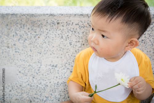 Asia cute baby boy holding white flower