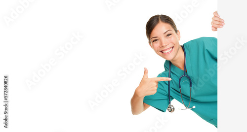 Medical sign person - woman showing blank poster billboard pointing. Young female nurse or medical doctor professional in green scrubs smiling happy isolated cutout PNG on transparent background. © Maridav