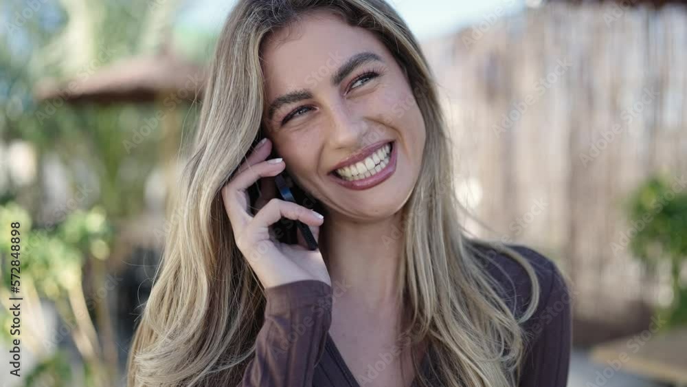 Young blonde woman smiling confident talking on the smartphone at street Young blonde woman smiling confident talking on the smartphone at street
