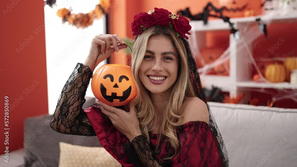 Young blonde woman wearing katrina costume holding pumpkin basket at home Young blonde woman wearing katrina costume holding pumpkin basket at home
