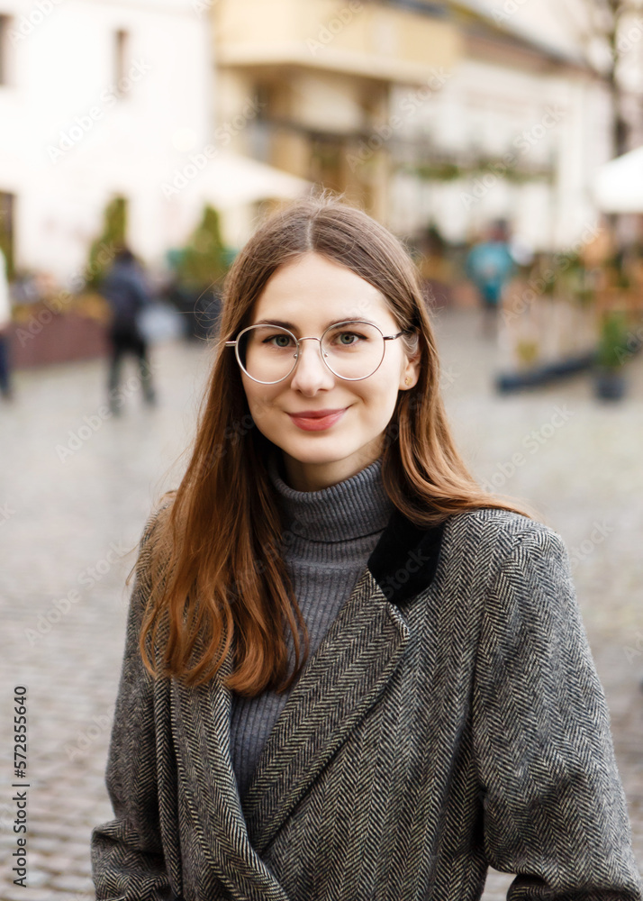 woman in a woolen coat walks alone in the middle of a spring city woman in a woolen coat walks alone in the middle of a spring city