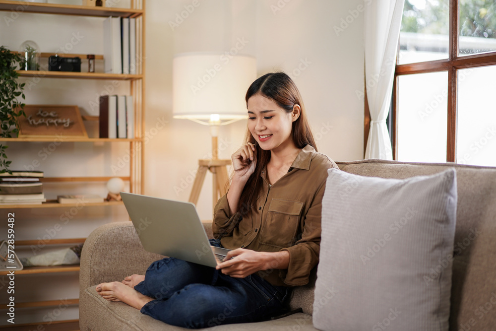 Fototapeta premium Female entrepreneur touching play her hair while sitting on big