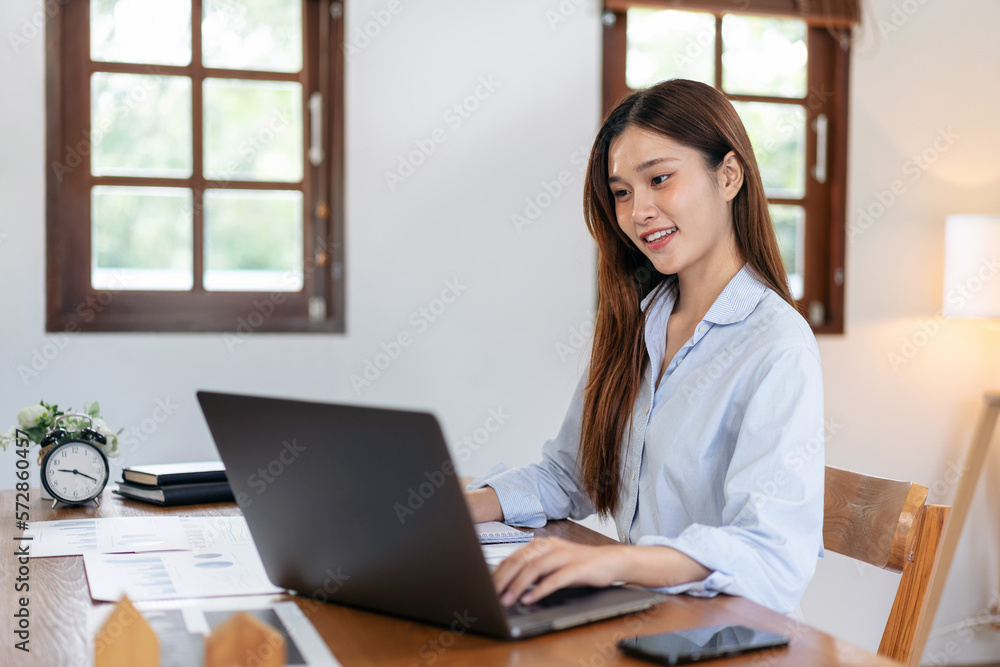 Female freelance is typing to search data on laptop and writing Female freelance is typing to search data on laptop and writing