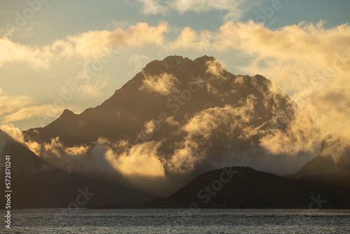 Himmeltindan mountain peak circled by clouds, VestvÃ¥gÃ¸y, Lofoten Islands, Norway photo