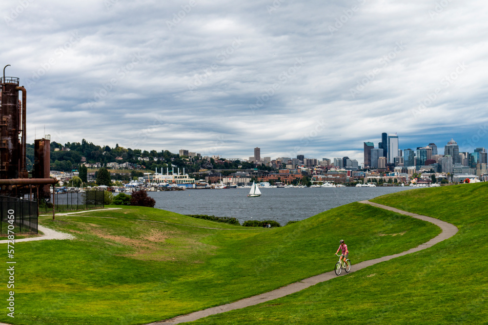 A woman rides her cruiser bike at Gasworks Park in Seattle, Washington on a cloudy day.