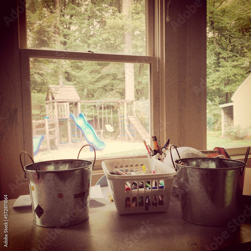 Child's play room and utensils with yard and playground equipment viewable through the window in the background