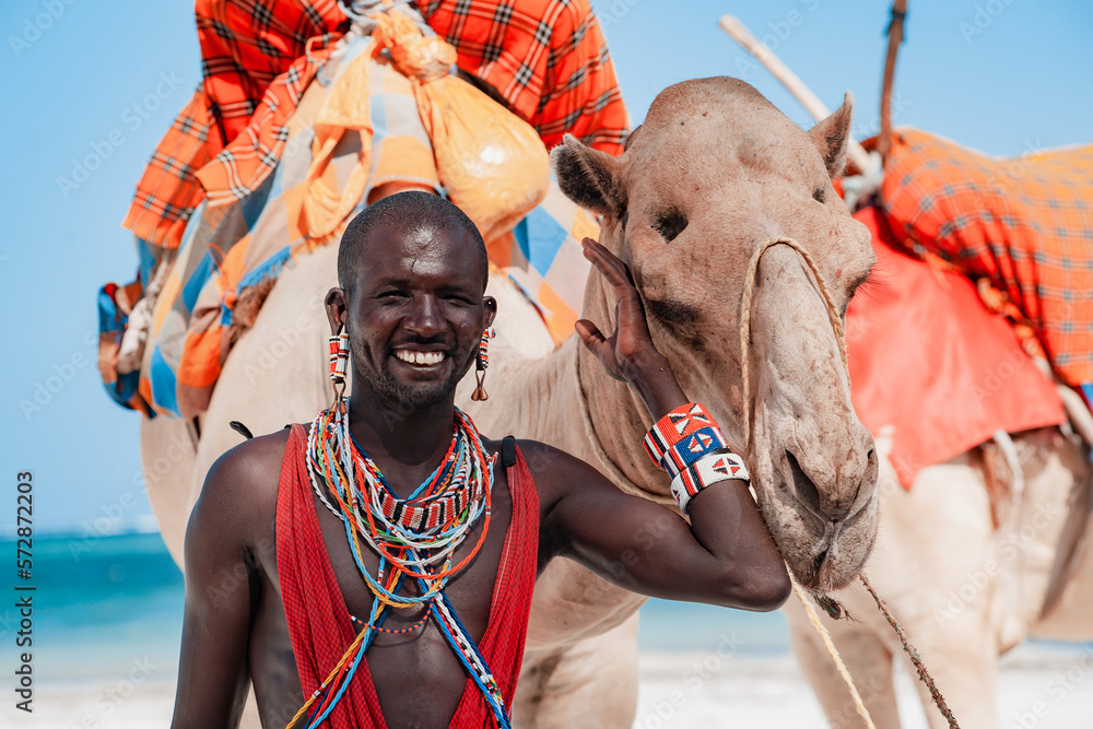 Maasai warrior with a camel, entertainment for tourists beach in Kenya - obrazy, fototapety, plakaty 