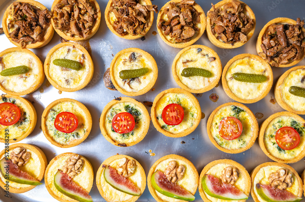 Flat lay photo of canape set cooked in bakery on metal tray. Big group of delicious snacks prepared for wine party in restaurant kitchen Flat lay photo of canape set cooked in bakery on metal tray. Big group of delicious snacks prepared for wine party in restaurant kitchen