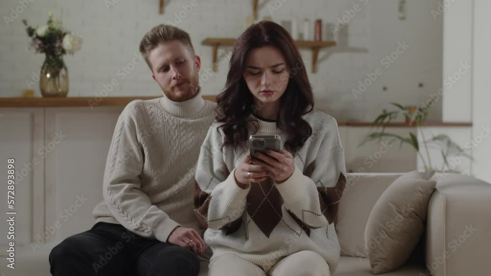 Man wants to check his girlfriend's phone. Couple have relationship problems. Trust issues. Brunette girl is cheating on her boyfriend. Man wants to check his girlfriend's phone. Couple have relationship problems. Trust issues. Brunette girl is cheating on her boyfriend.