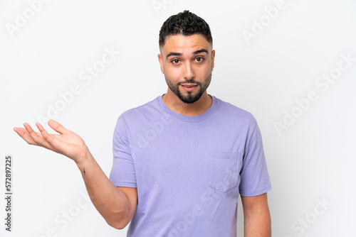 Young Arab handsome man isolated on white background making doubts gesture