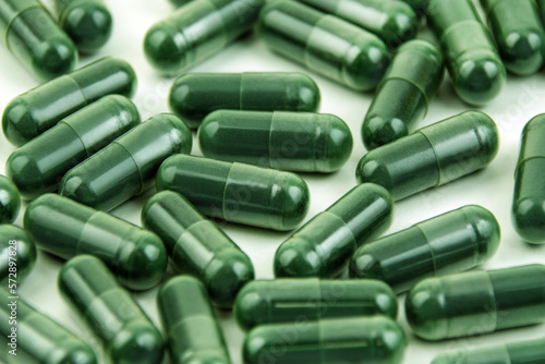 Green Spirulina capsules close up