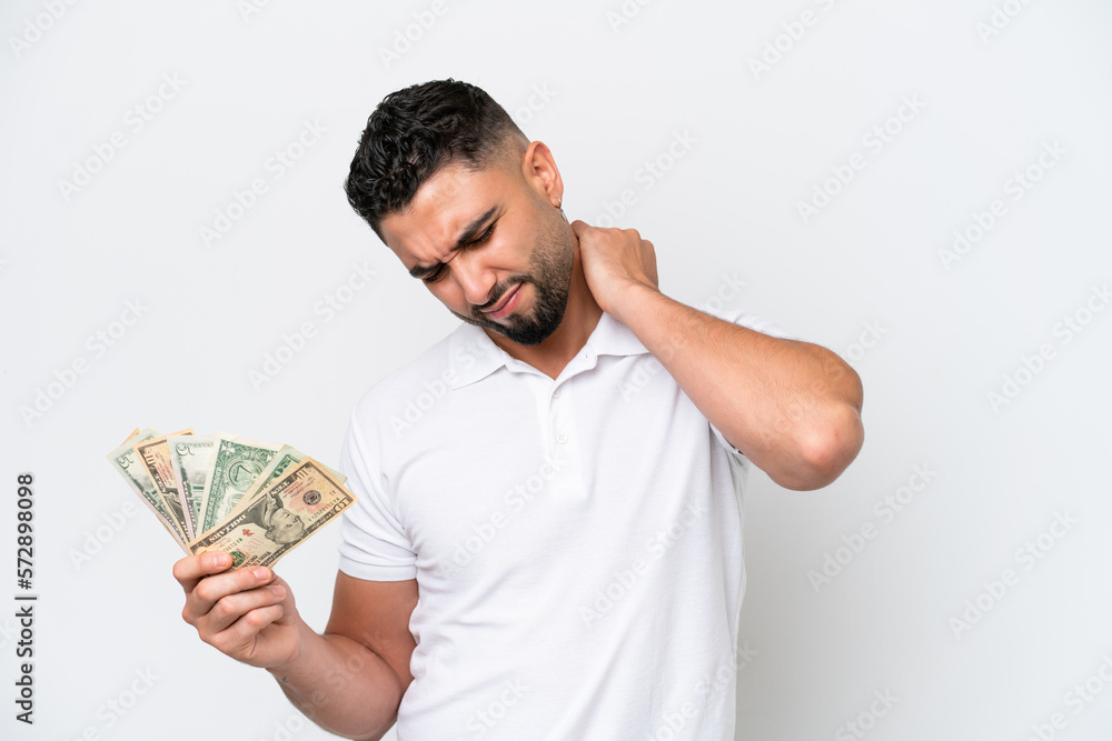 Young Arab man taking a lot of money isolated on white background suffering from pain in shoulder for having made an effort Young Arab man taking a lot of money isolated on white background suffering from pain in shoulder for having made an effort