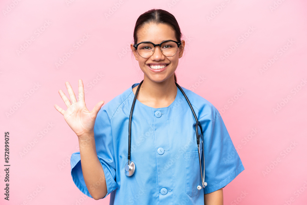 Young nurse Colombian woman isolated on pink background counting five with fingers Young nurse Colombian woman isolated on pink background counting five with fingers