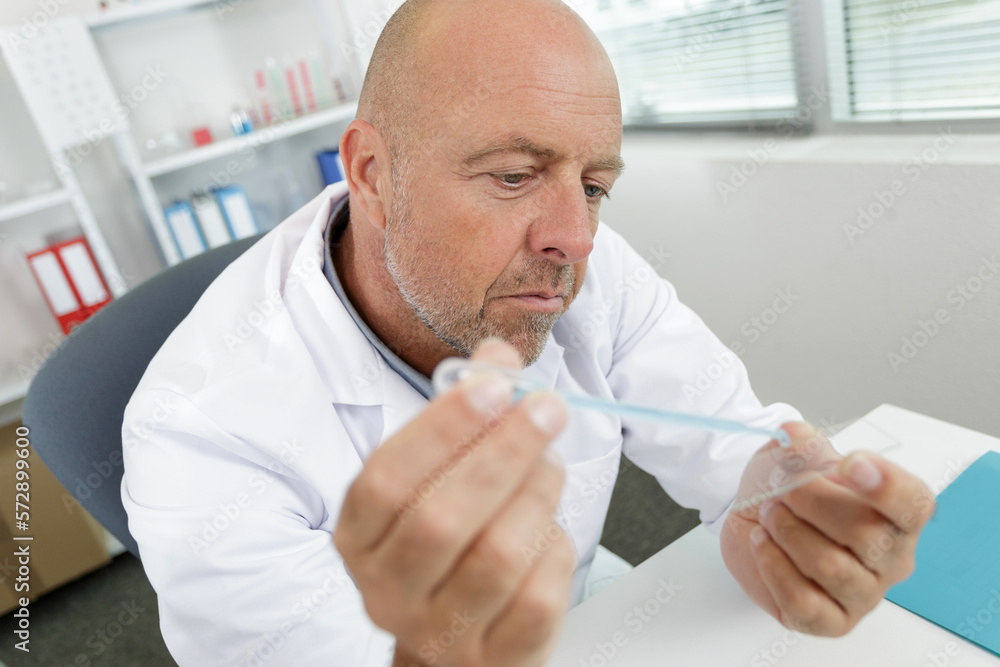 man pouring chemical liquid in a test tube man pouring chemical liquid in a test tube