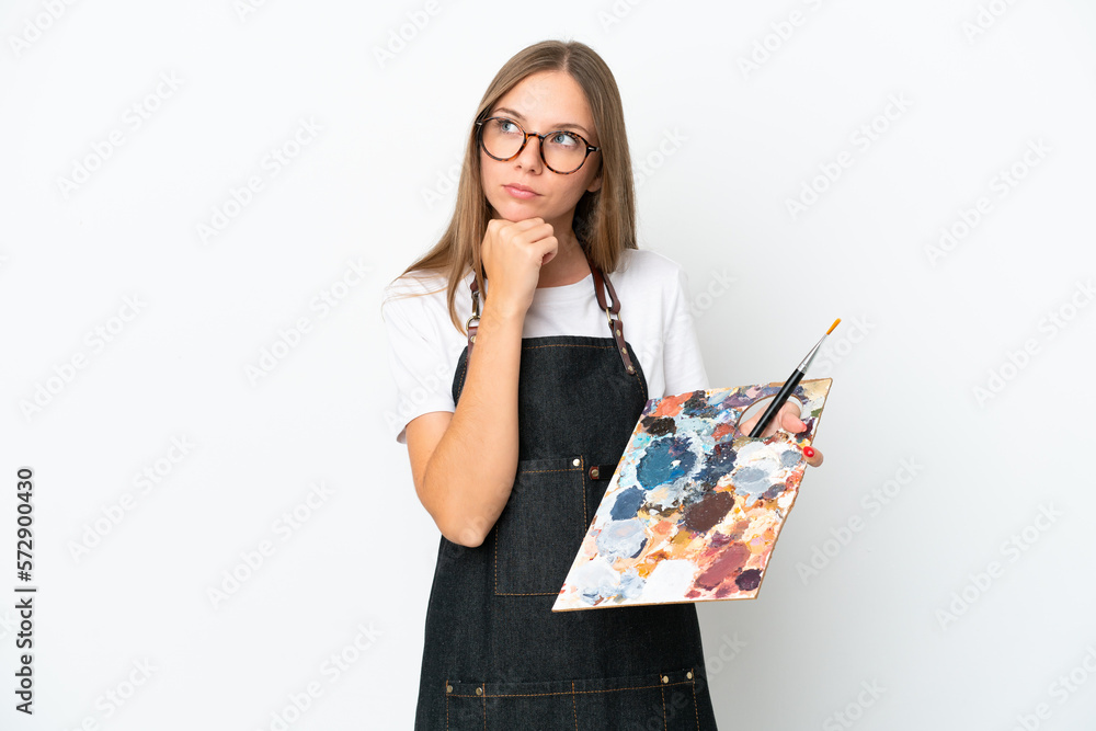Young artist Lithuanian woman holding a palette isolated on white background and looking up Young artist Lithuanian woman holding a palette isolated on white background and looking up