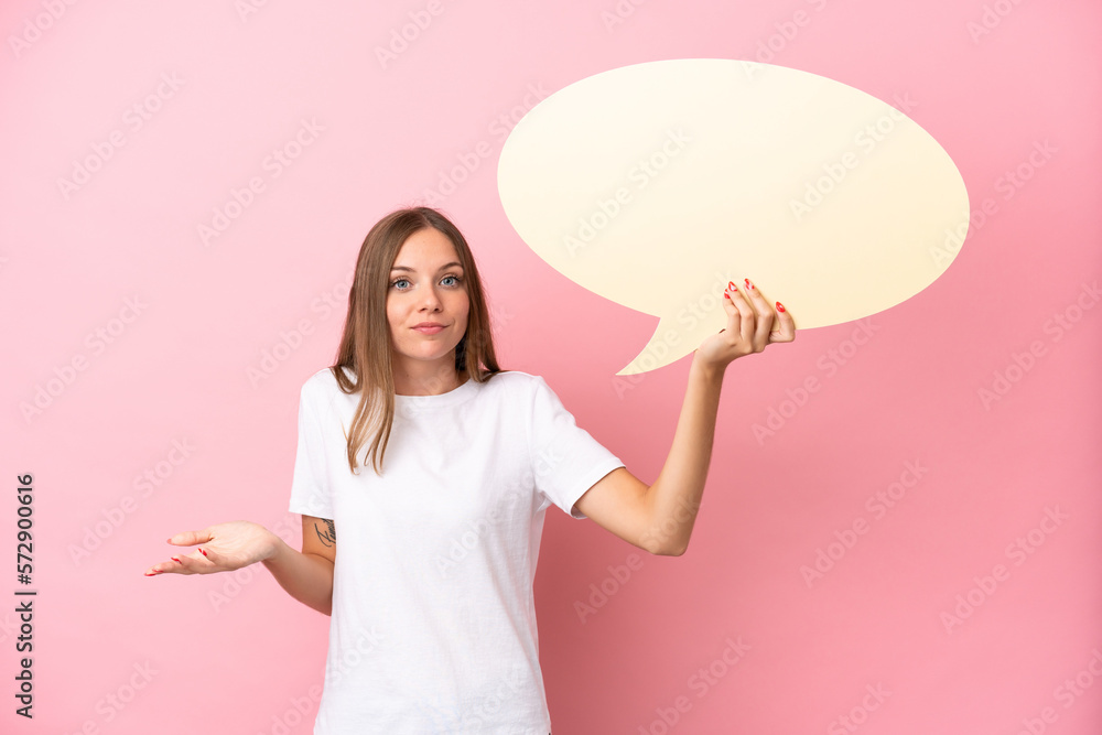 Young Lithuanian woman isolated on pink background holding an empty speech bubble and having doubts Young Lithuanian woman isolated on pink background holding an empty speech bubble and having doubts