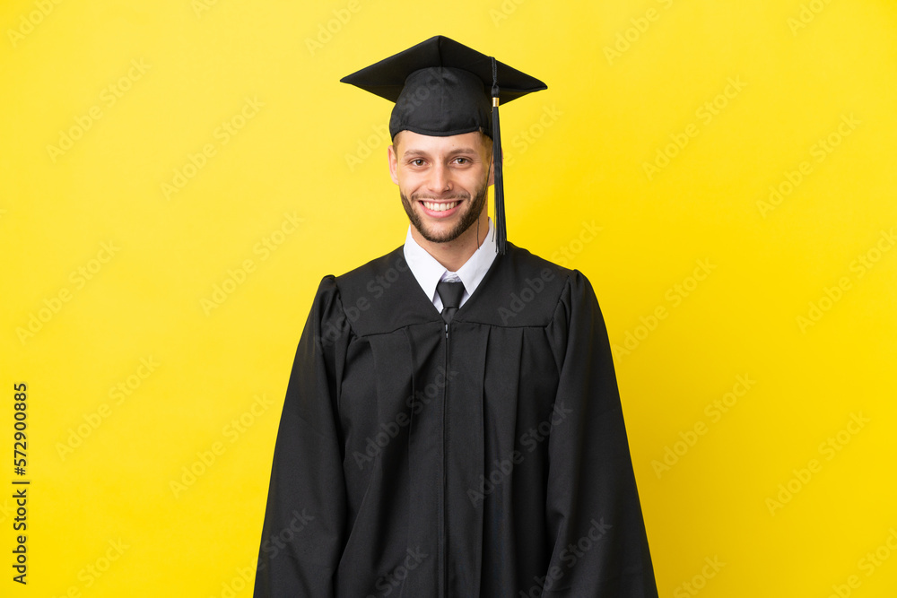 Young university graduate caucasian man isolated on yellow background laughing
