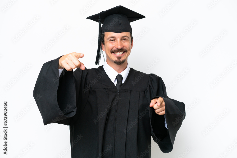 Young university graduate man isolated on white background points finger at you while smiling Young university graduate man isolated on white background points finger at you while smiling