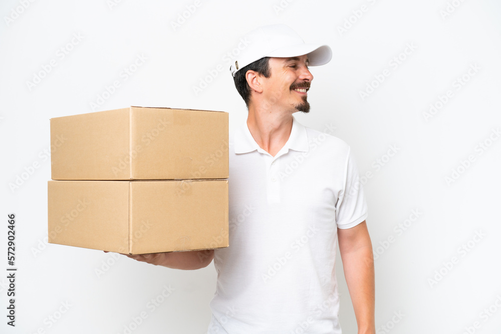 Delivery caucasian man isolated on white background looking side Delivery caucasian man isolated on white background looking side