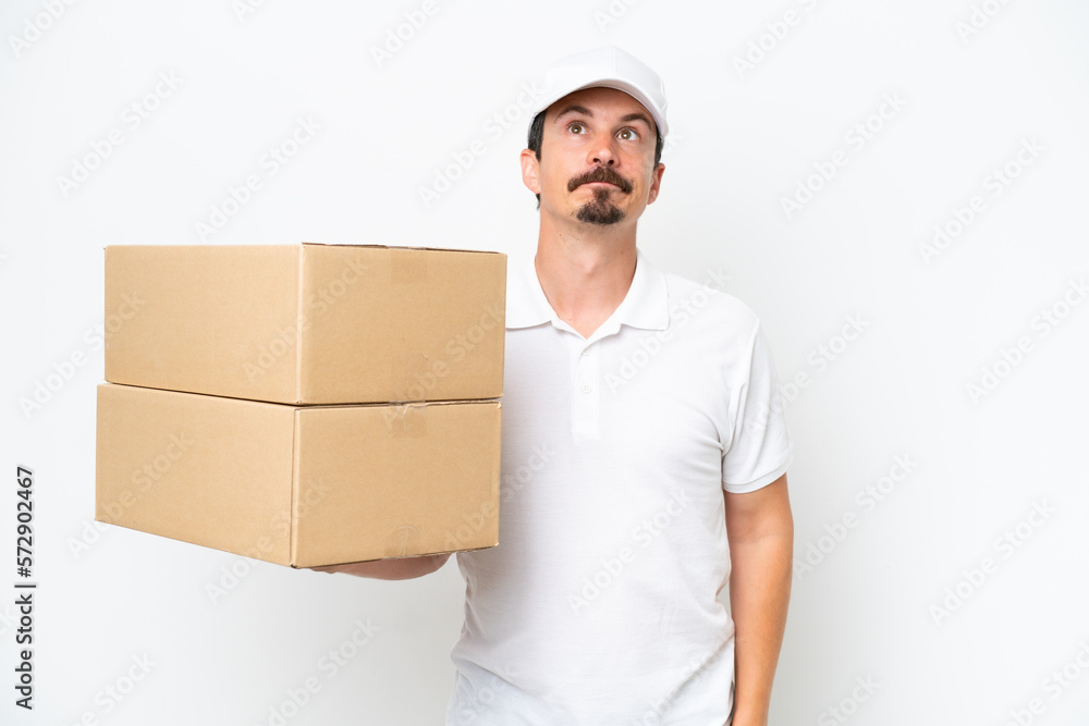 Delivery caucasian man isolated on white background and looking up Delivery caucasian man isolated on white background and looking up
