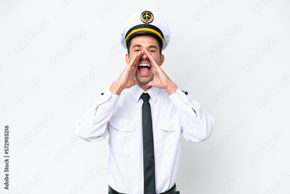 Airplane pilot over isolated white background shouting and announcing something Airplane pilot over isolated white background shouting and announcing something