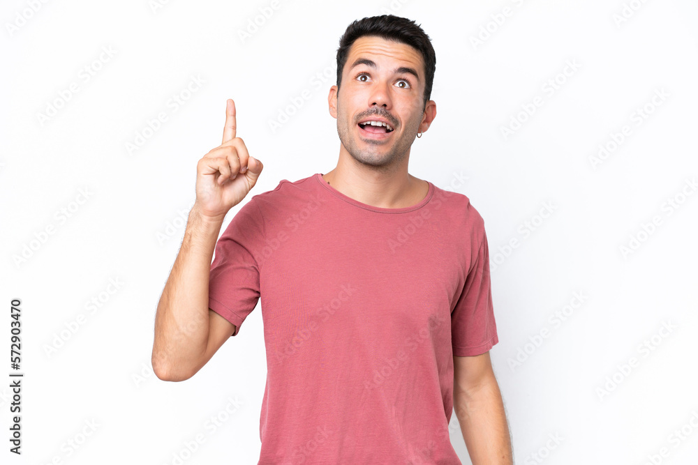 Young handsome man over isolated white background pointing up and surprised Young handsome man over isolated white background pointing up and surprised