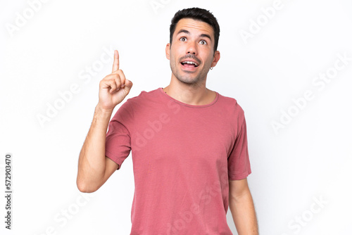 Young handsome man over isolated white background pointing up and surprised