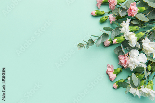 Fototapeta Naklejka Na Ścianę i Meble -  A bouquet of white and pink carnations with eucalyptus branches on a soft green background.