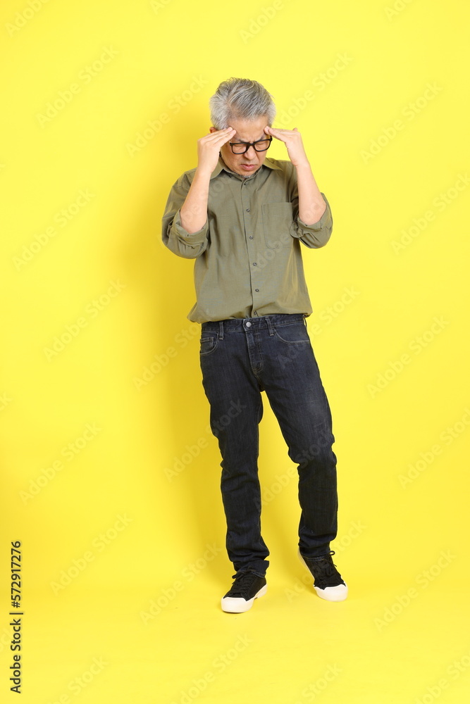 Φωτογραφία The 40s adult Asian man with casual dressed standing on the yellow background