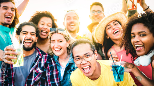 Multiracial friends taking selfie at sunset concert on vacation day - Party life style concept with young people having fun together at spring break beach festival - Vivid filter with sunshine halo