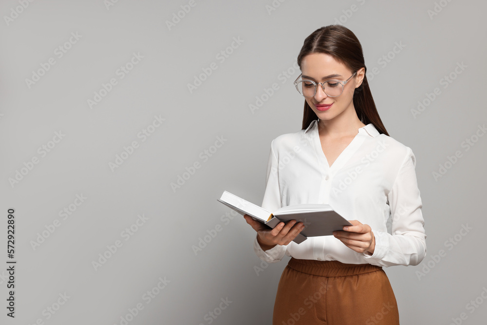 Portrait of beautiful young teacher on grey background. Space for text Portrait of beautiful young teacher on grey background. Space for text