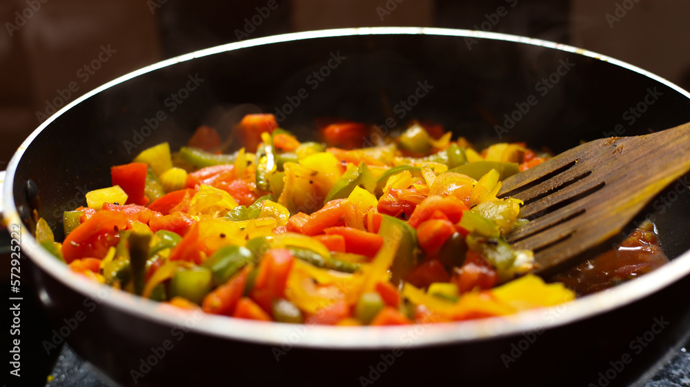 Close-up view of mix of colored vegetables cooking over pan. steaming mixed vegetables in the wok, asian style cooking vegetarian and healthy Close-up view of mix of colored vegetables cooking over pan. steaming mixed vegetables in the wok, asian style cooking vegetarian and healthy