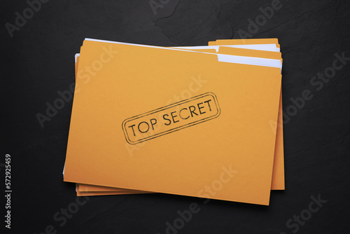 Konstfotografi Yellow file with documents and Top Secret stamp on black table, top view