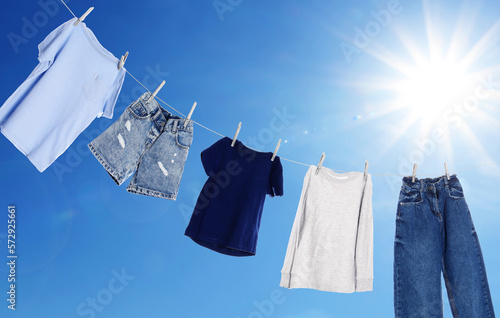 Slika na platnu Different clothes drying on washing line against blue sky