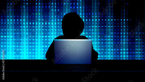 Dunkle Person mit Kapuze als Silhouette vor einem geöffneten Laptop und digitalem Hintergrund