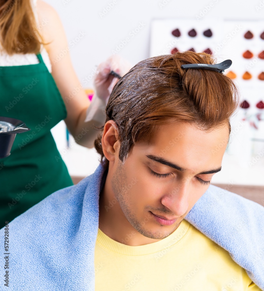 Naklejka premium Woman hairdresser applying dye to man hair