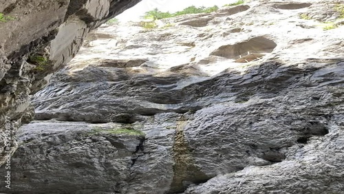 Switzerland canyon in Grindelwald. Big grey boulders and rocks. River in the  huge canyon. Waterfall from the rocks. Summer sunny hiking day. Natural landscapes in Switzerland canyon and forest. 
