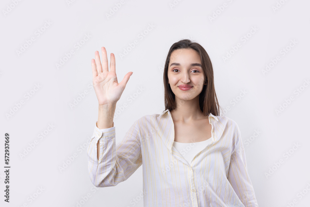 Smiling woman raised her hand palm up and forward like waving. Smiling woman raised her hand palm up and forward like waving.