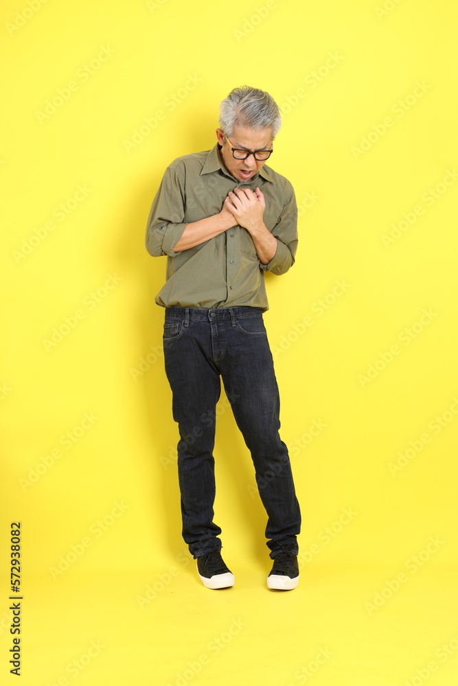 Fototapeta premium The 40s adult Asian man with casual dressed standing on the yellow background.