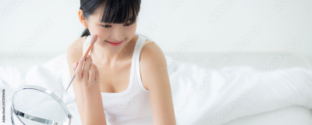 Beauty of young asian woman with learning makeup with brush on cheek on laptop computer with tutorial course online on bed, female teaching and explain make up with cosmetic on streaming social media. Beauty of young asian woman with learning makeup with brush on cheek on laptop computer with tutorial course online on bed, female teaching and explain make up with cosmetic on streaming social media.