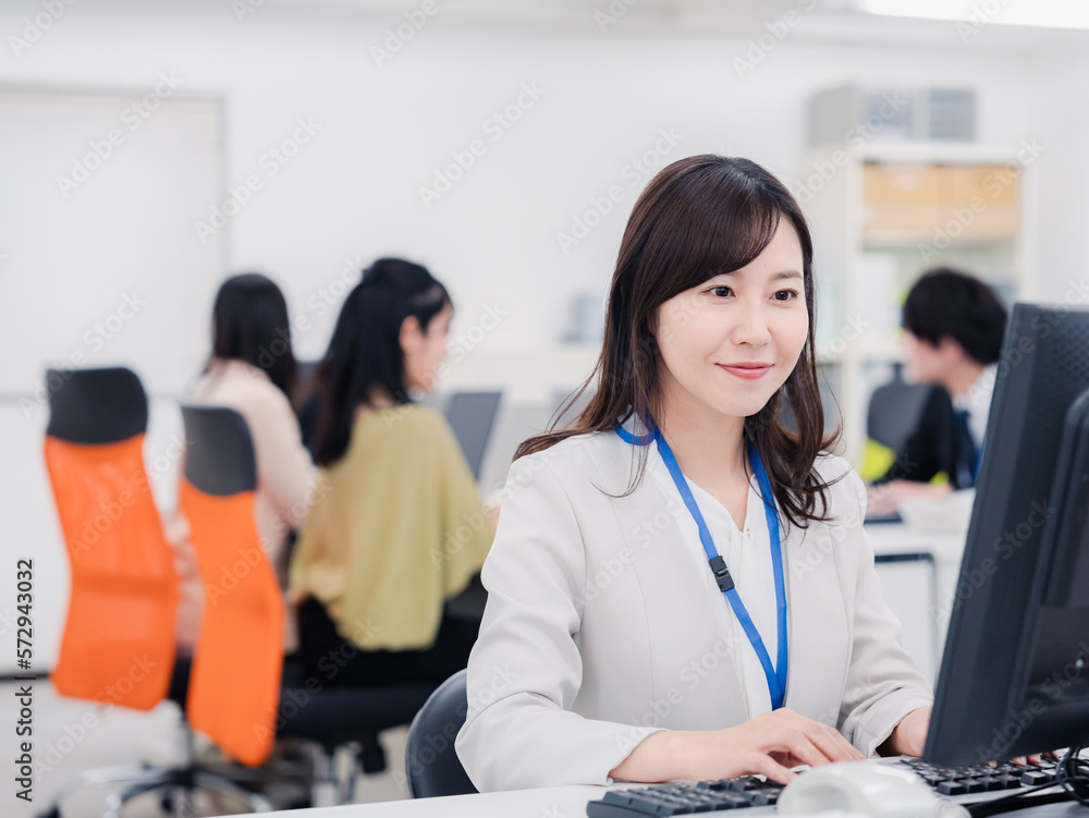笑顔でデスクワークをする女性 笑顔でデスクワークをする女性