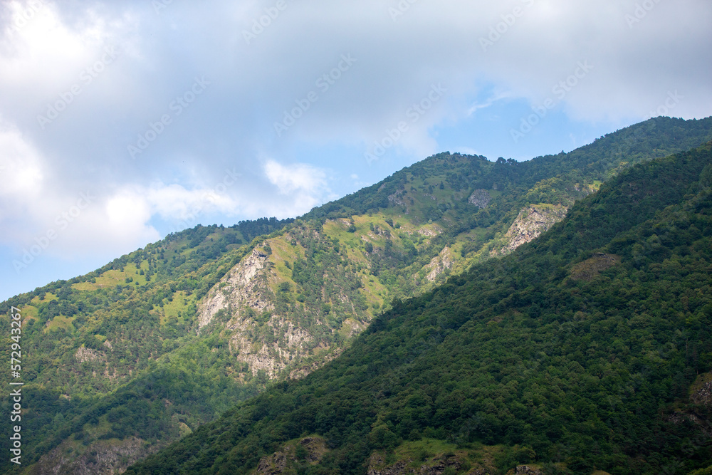 Mountain landscape. Mountains with vegetation against the blue sky.