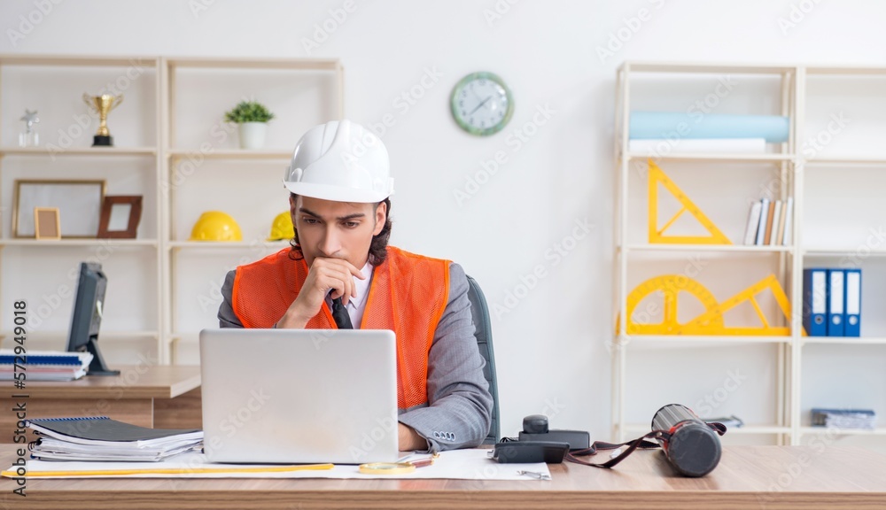 Young male architect working in the office Young male architect working in the office